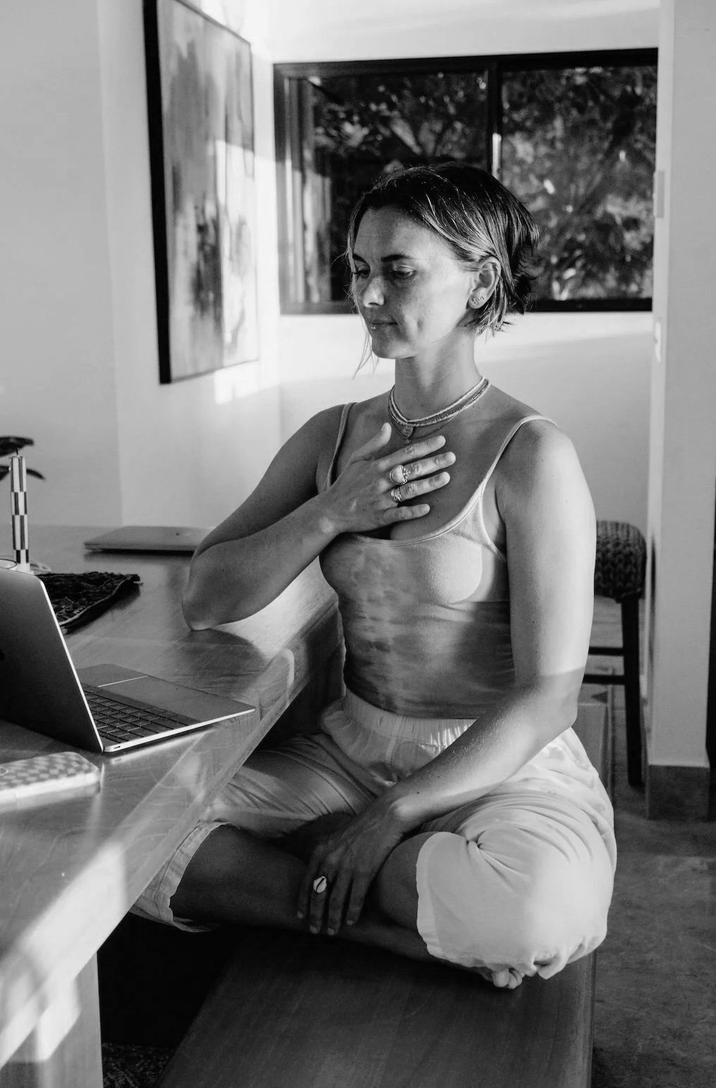 A member on an online call, one hand resting on her chest