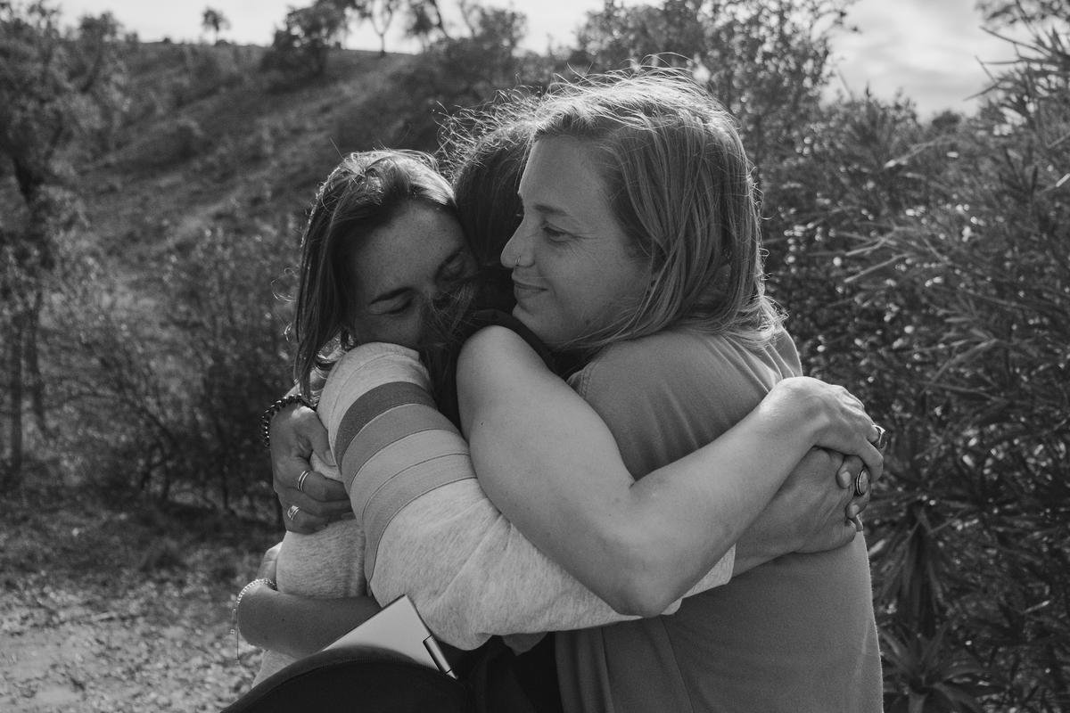 Three RYMERS in a long hug outdoors after a session
